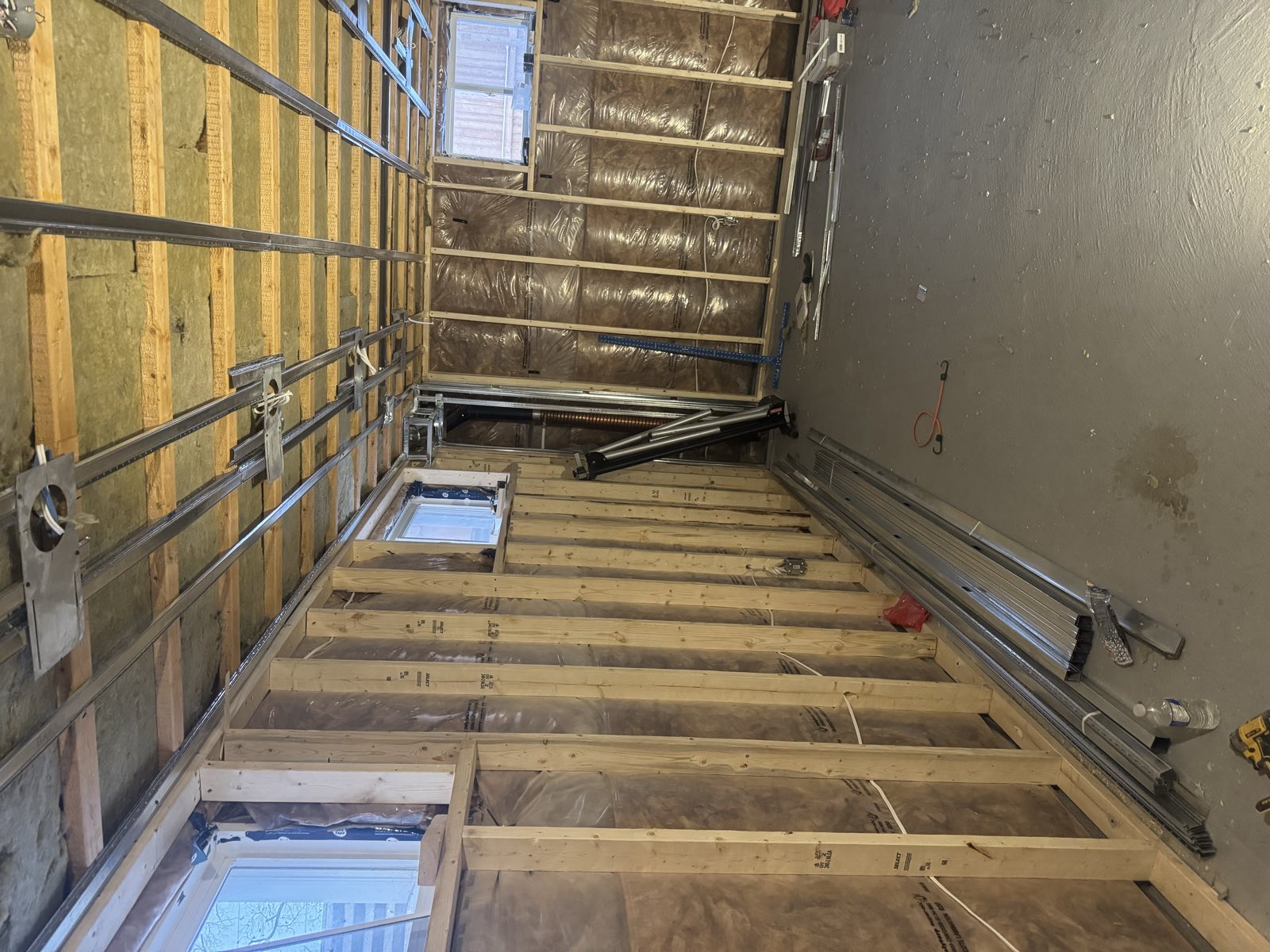Basement room framed with steel track and filled with batt insulation before boarding